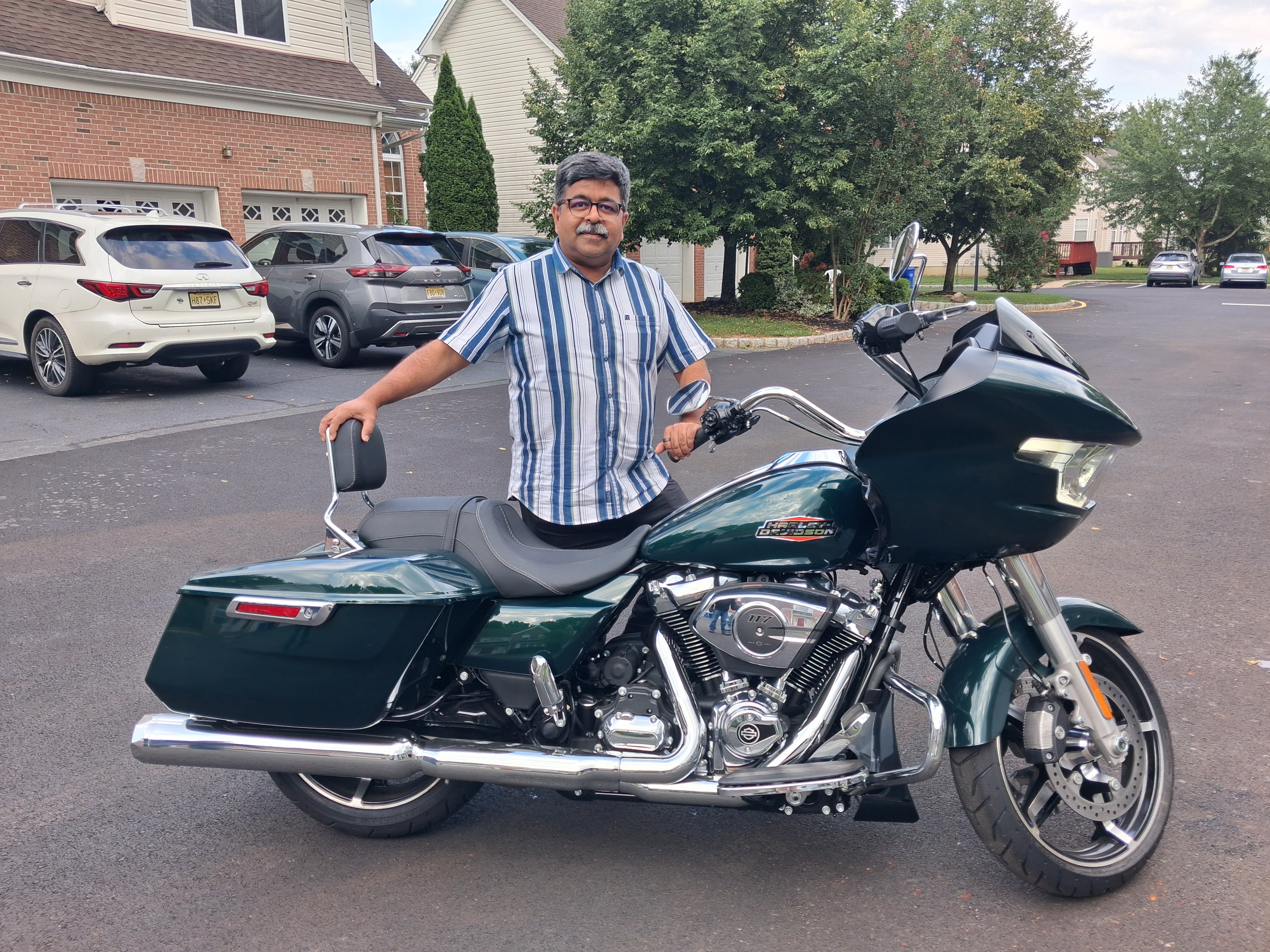 Siddharth Joshi standing beside a green touring motorcycle in North Brunswick, New Jersey